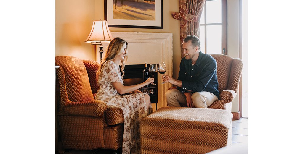 Couple enjoying The Judge wine in their Deluxe Suite at The Villa