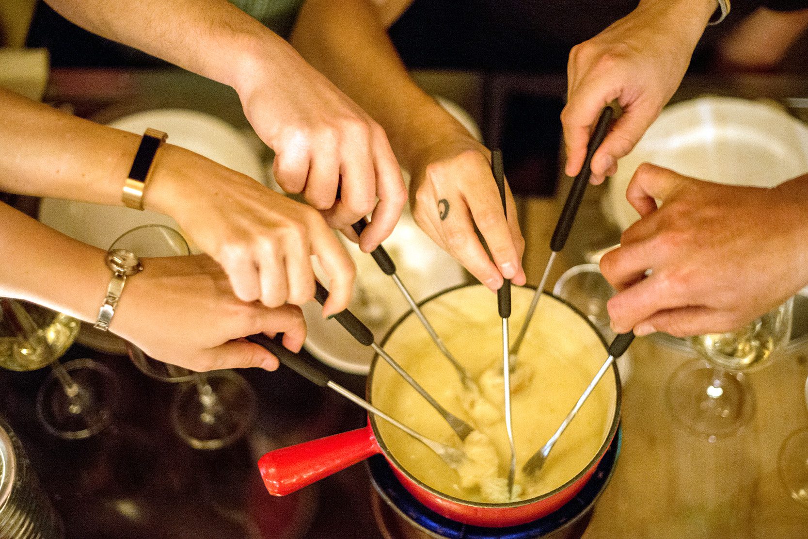 Hands dipping into fondue